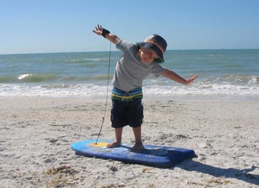 Little kid playing on boogie board on Sanibel Island Beach