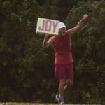 Arthur Warner, a 75-year-old Sanibel Island resident, walks a two-hour route nearly every day waving a big red ‘JOY’ sign for all to see.